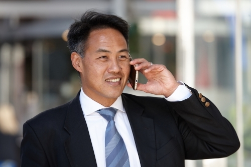 Asian businessman in city - Australian Stock Image