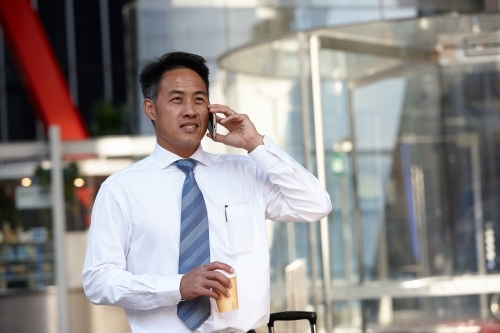 Asian businessman in city - Australian Stock Image