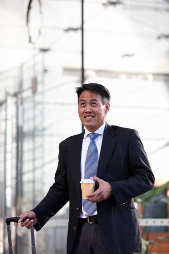 Asian businessman in city - Australian Stock Image