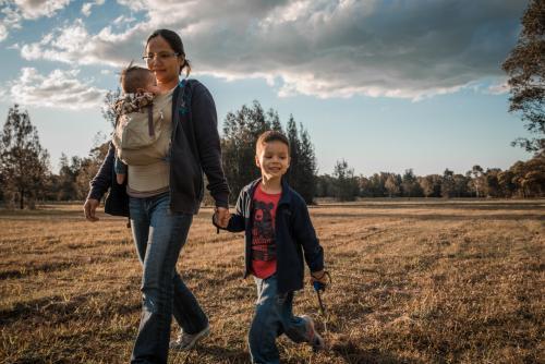 Asian mother walks with her mixed race boys in a Sydney suburban park - Australian Stock Image