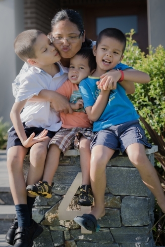 Asian mum sending her boys off to school on their first day of school - Australian Stock Image