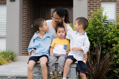 Asian mum sending her boys off to school on their first day of school - Australian Stock Image