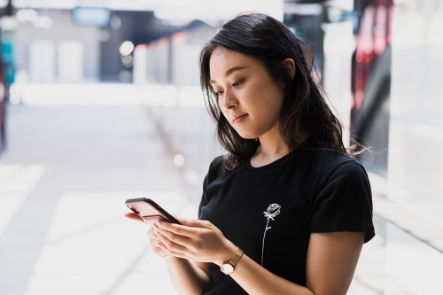 asian woman at train station - Australian Stock Image