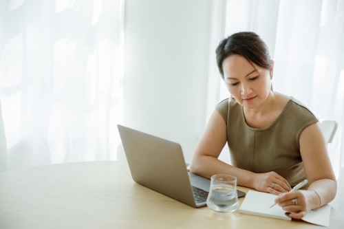 Asian woman working on a computer - Australian Stock Image