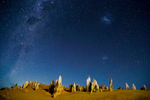 Astrophoto of The Pinnacles, with Milky Way, Magellanic Clouds, and stars at night. - Australian Stock Image