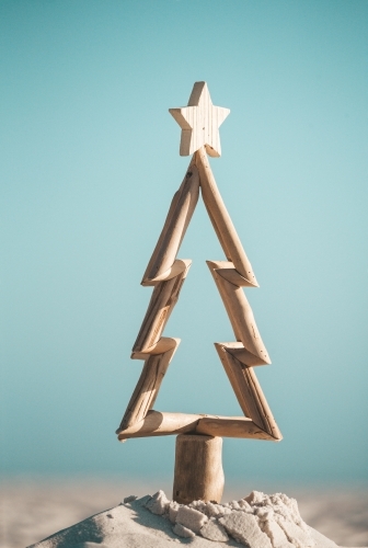 Australian Christmas.  Driftwood timber Christmas tree in sand by the ocean - Australian Stock Image