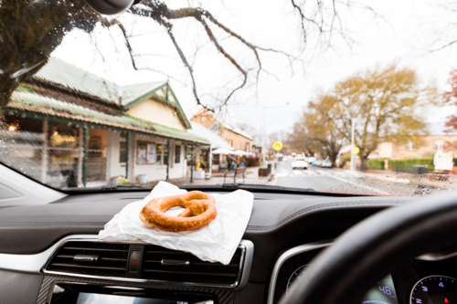 Authentic German pretzel on dashboard of car parked in Hahndorf, Germany inspired town in SA - Australian Stock Image
