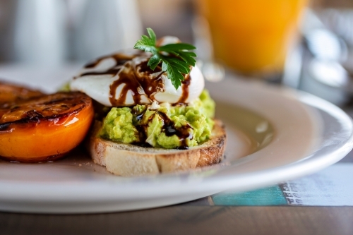 Avocado toast with egg and roasted tomato - Australian Stock Image