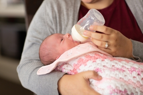 Baby girl being bottle fed - Australian Stock Image