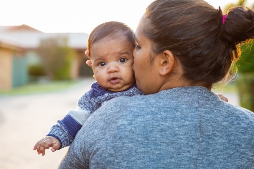 Baby looking over his mother's shoulder - Australian Stock Image