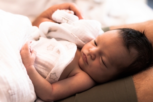 Baby on dad's laps - Australian Stock Image