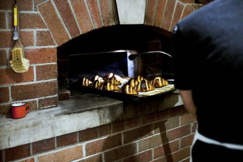 Baker taking croissants out of the oven - Australian Stock Image
