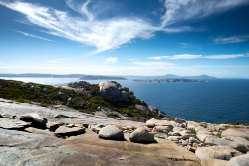 Bald Head trail view overlooking the ocean with smooth coastal rocks in the foreground. - Australian Stock Image