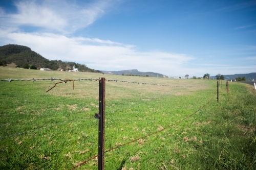 barbed wire fencing on farmland - Australian Stock Image