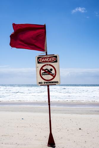 Beach closed sign in front of rough white water on the Gold Coast - Australian Stock Image