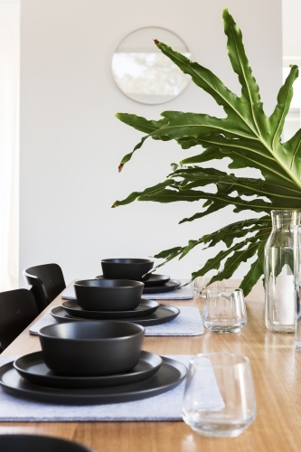 Beautiful stone crockery table setting with large green centerpiece - Australian Stock Image