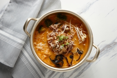Beef laksa noodle soup with broccoli, dried seaweed, and spring onions - Australian Stock Image