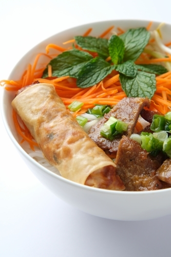 Beef noodle salad topped with fried lumpia - Australian Stock Image