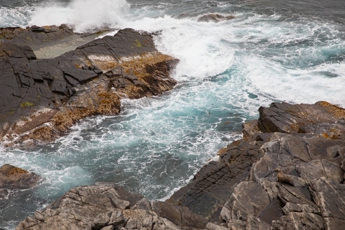 Big waves crashing against the jagged rocks - Australian Stock Image