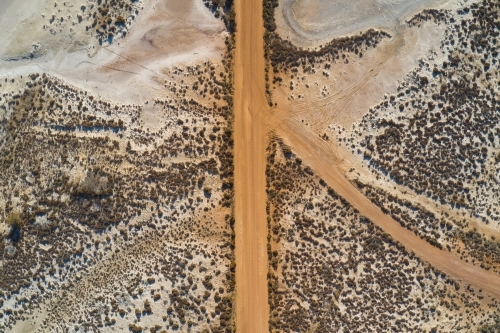 Bird's eye view of a section of dusty gravel road between dry salt lakes in Western Australia. - Australian Stock Image