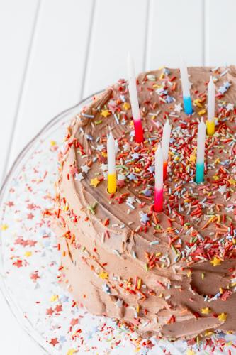 birthday cake with chocolate icing, sprinkles and candles