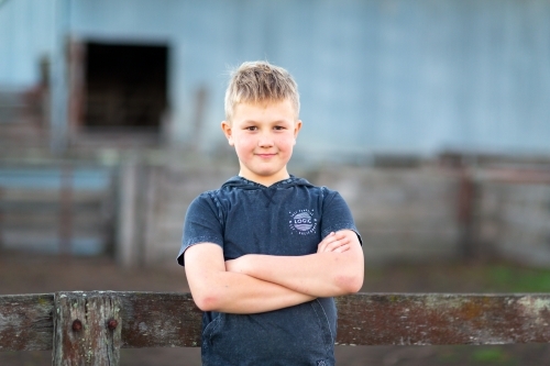 Blonde boy outdoors with arms crossed - Australian Stock Image