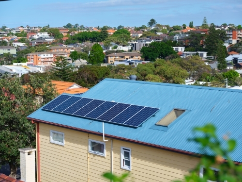Blue colored roof with solar panels and a view with houses - Australian Stock Image