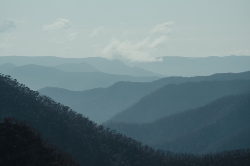 Blue mountain layers through the valley at Kanangra Walls Lookout on a sunny day - Australian Stock Image