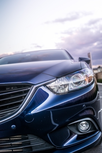 Blue station wagon on suburban street with luxury homes - Australian Stock Image