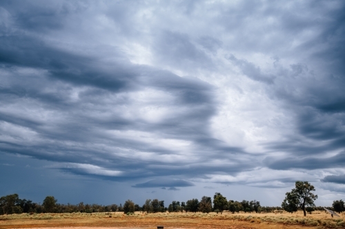 Blue stormy sky in a dry rural landscape - Australian Stock Image