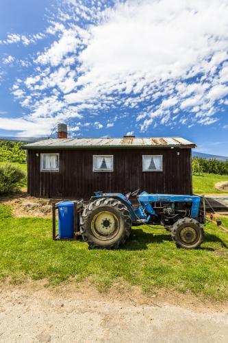 Blue tractor in front of small building - Australian Stock Image