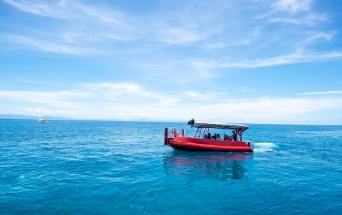 boat riding at the great barrier reef over blue water - Australian Stock Image