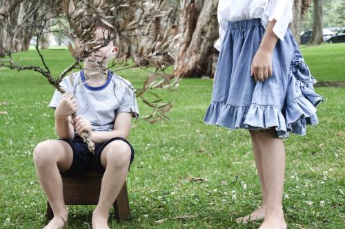 Boy and girl playing on green lawn of a park - Australian Stock Image
