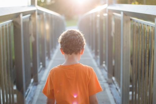 Boy crossing bridge - Australian Stock Image