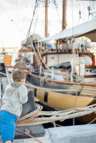 Boy on wharf marina with boats - Australian Stock Image