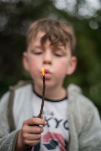 Boy playing with campfire - Australian Stock Image