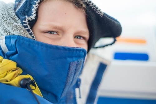 Boy rugged up with beanie and jacket on winter day - Australian Stock Image