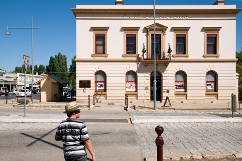 Boy stands outside of a historic building in regional Australia - Australian Stock Image