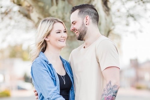 Boyfriend and girlfriend in arms laughing at each other - Australian Stock Image
