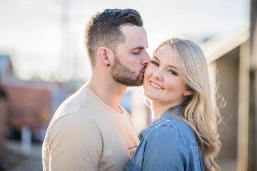 Boyfriend kissing smiling girlfriend on cheek