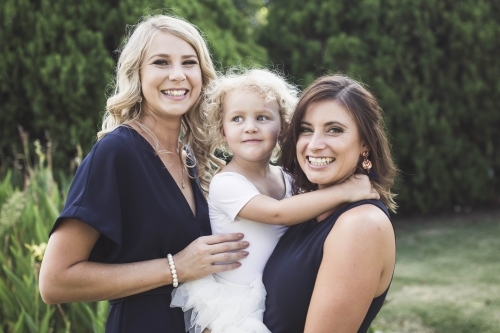 Bridesmaids with flower girl in garden at wedding - Australian Stock Image