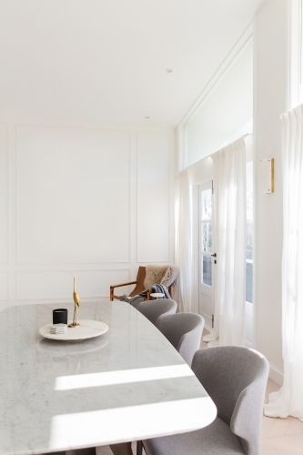 bright white interior with marble and brass decorations table and chairs - Australian Stock Image