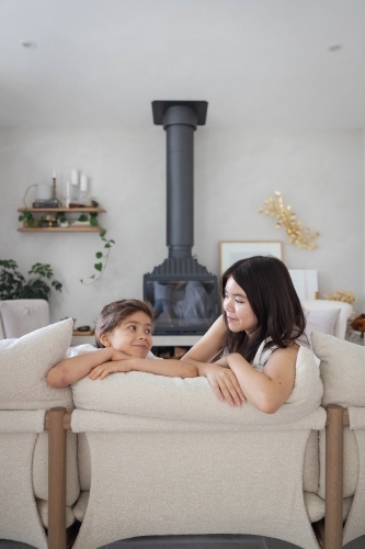 Brother and sister on couch at home together - Australian Stock Image