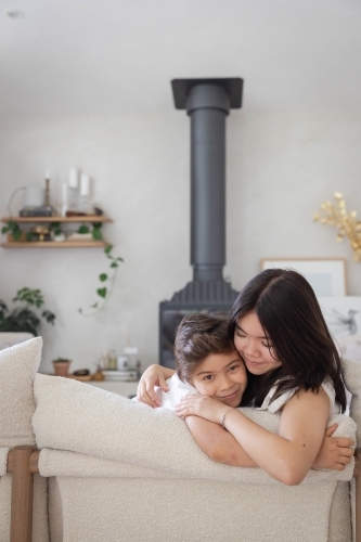 Brother and sister on couch at home together - Australian Stock Image