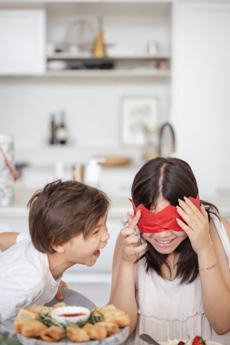 Brother and sister playing with paper crown - Australian Stock Image