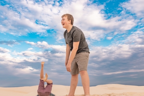 Brothers having fun on the sand dunes at Stockton Beach NSW - Australian Stock Image