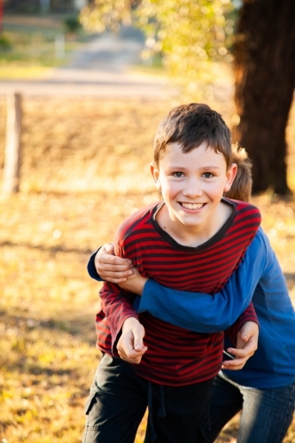 Brothers tackle wrestling each other outside - Australian Stock Image