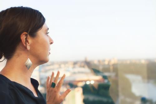 Business woman looking out of city office window - Australian Stock Image