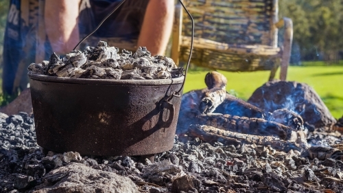 Camp oven over hot coals - Australian Stock Image