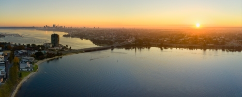 Canning Bridge and river in Perth, Australia as the sun rises on the horizon, with still water